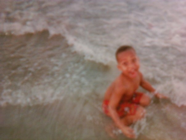 Young child smiling in the ocean waves at the beach