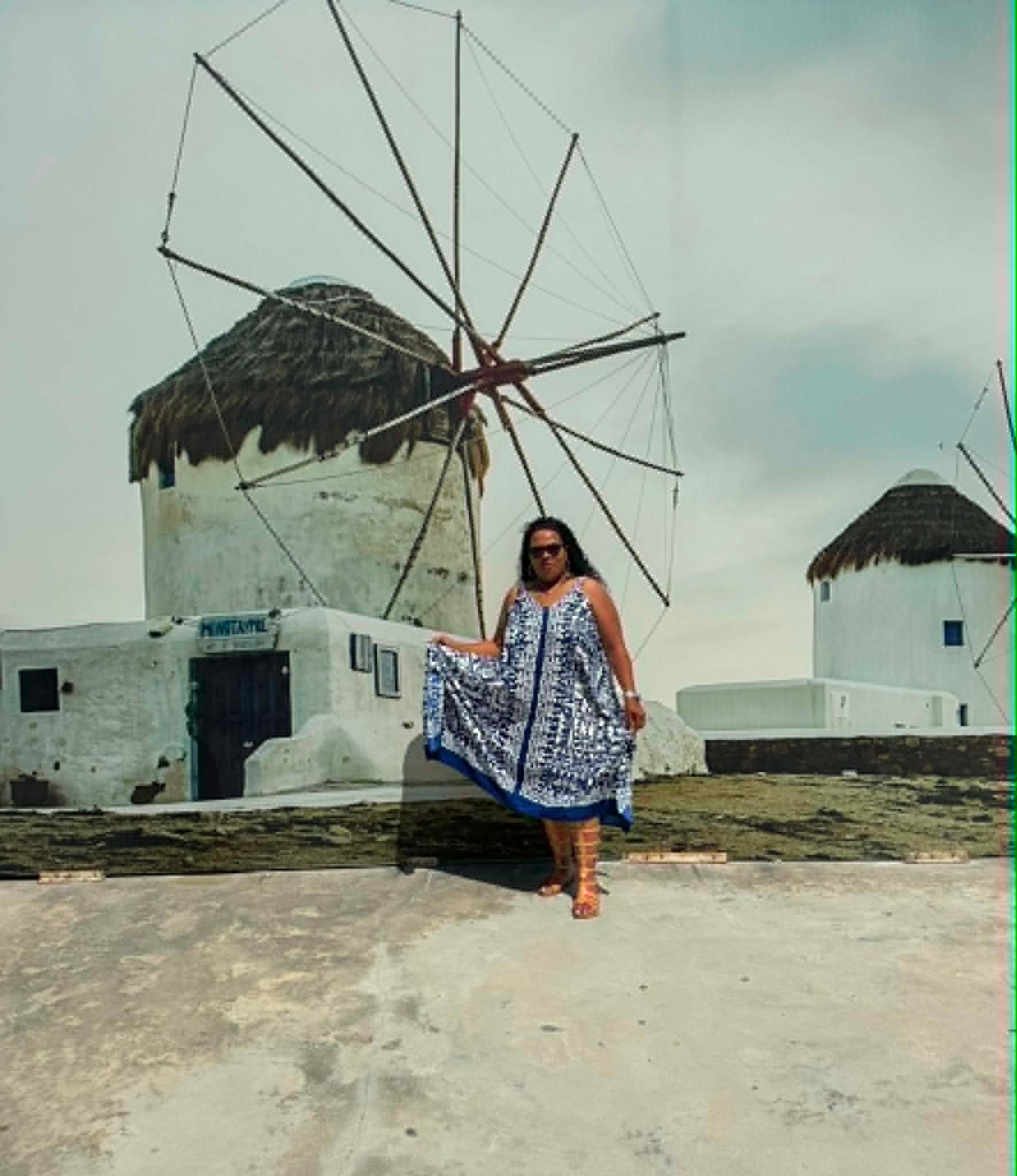 Ms. Mia in a blue and white dress at the Mykonos windmills