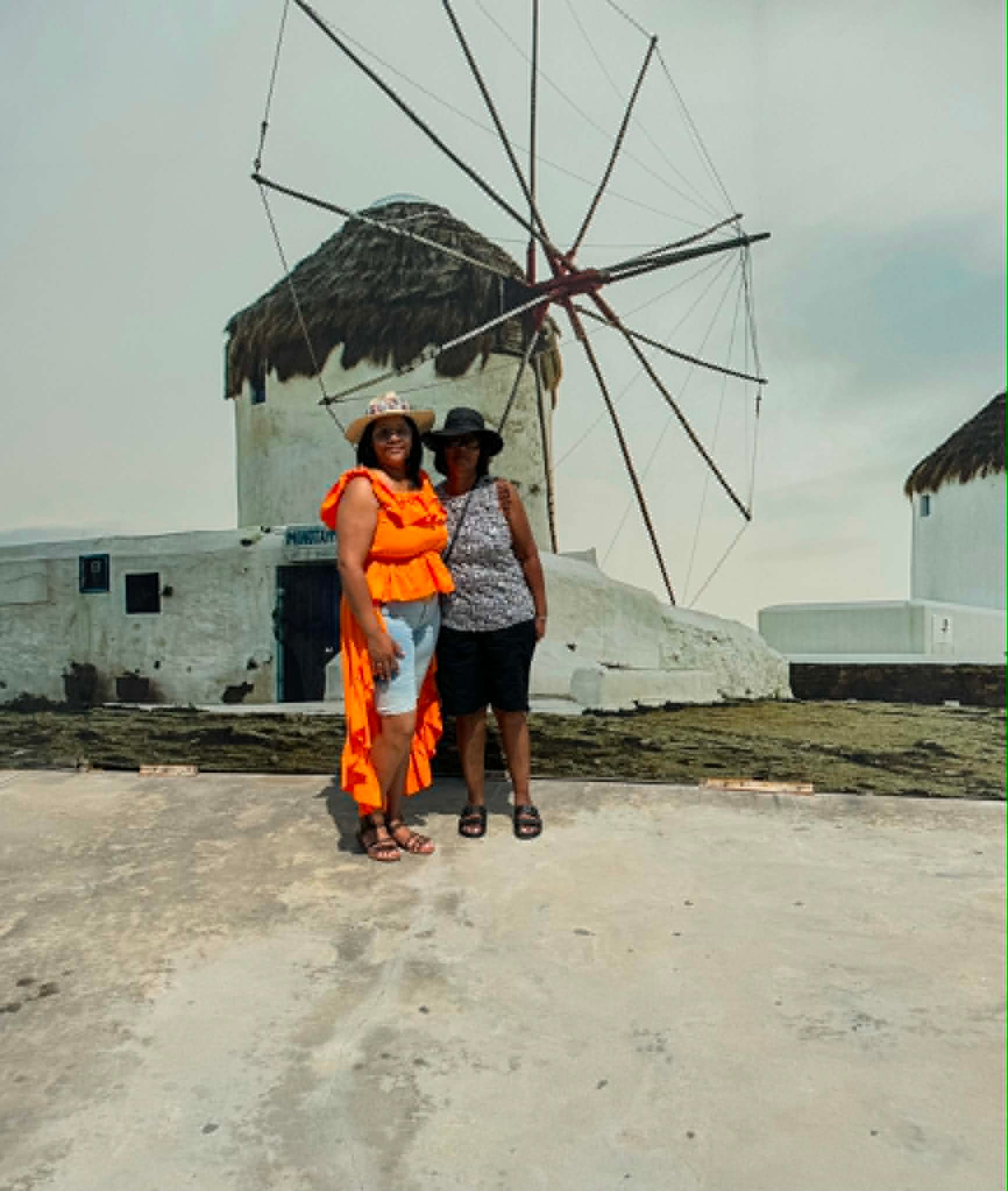 Mother and daughter posing in front of Mykonos windmill