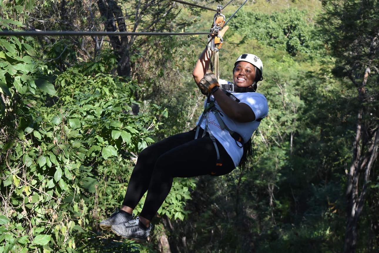 Sheena zip-lining through forest canopy