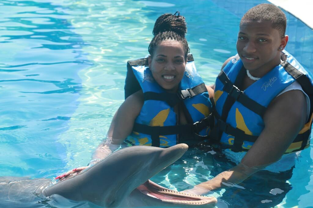 Ms. Mia and her son enjoying a dolphin experience on their travels