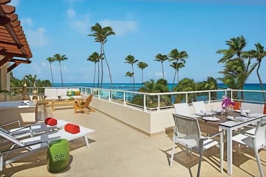 Oceanview terrace with dining and palm trees